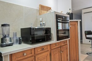A modern kitchen with a Kenwood blender, a Samsung microwave, and a built-in oven.