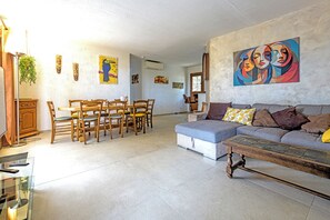 A living room with a sofa, a dining table with chairs, and a coffee table. - Villa "La Couaste": Enjoy life in Provence. (Lorgues)