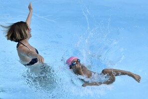 Dos personas nadando en una piscina.
