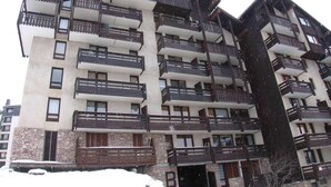 A multi-story building with balconies, stone facade, and a visible entrance. - 250m from resort center, 3rd floor, terrace, tv, ski locker, 45m², Risoul (Risoul)