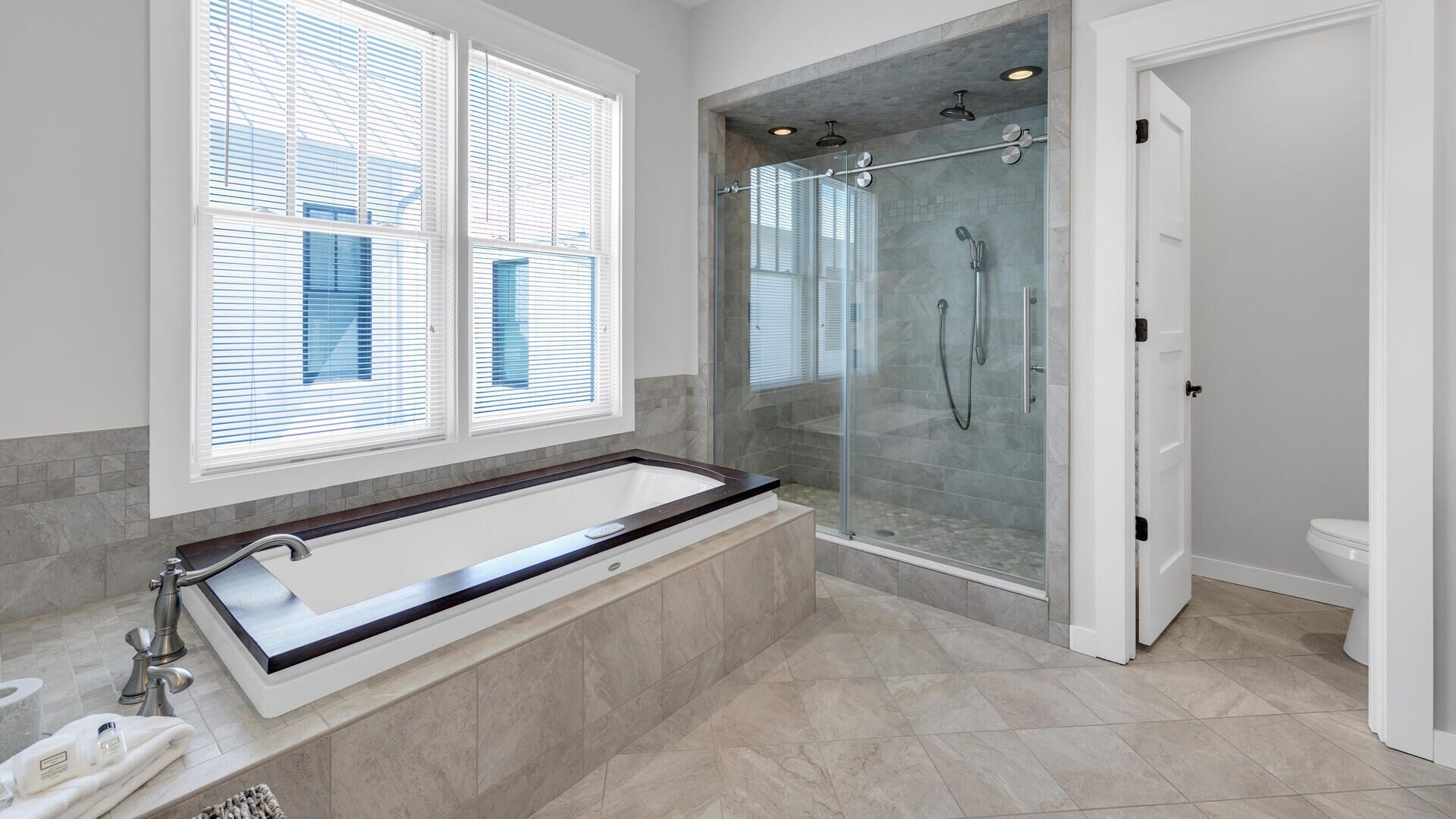 A modern bathroom with a large freestanding bathtub, a glass-enclosed shower, and a toilet.