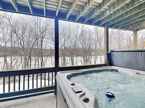 A hot tub with a view of a snowy landscape through large windows. - Duck Cove at Wisp by Taylor Made Deep Creek (McHenry)