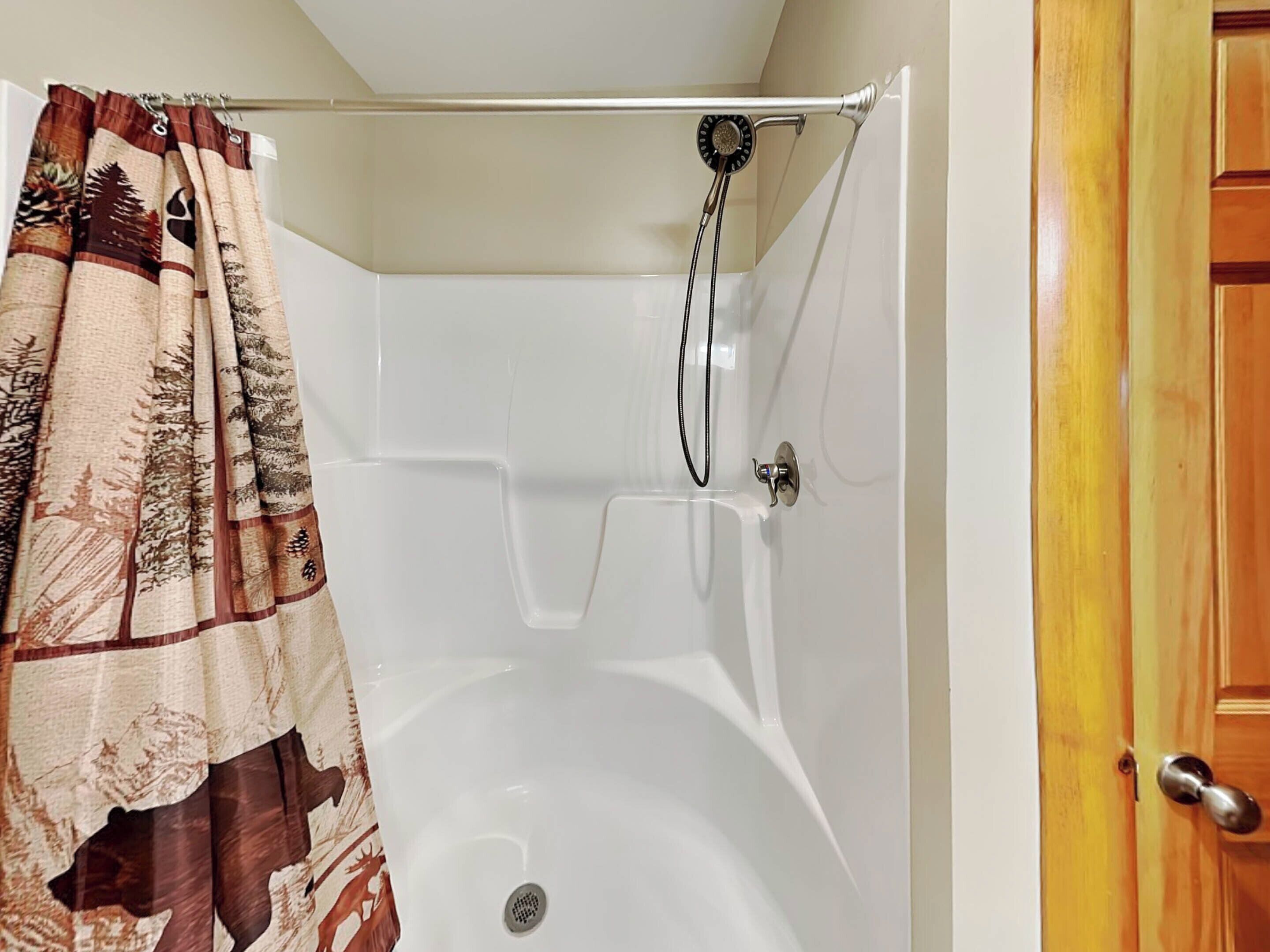 Une salle de bain avec une baignoire, une douche et une porte en bois.