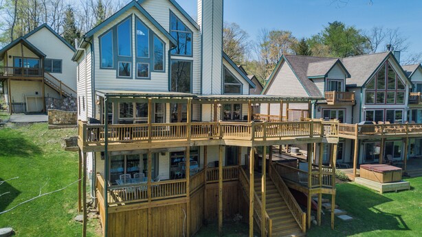 A multi-story house with a wooden deck and a balcony.