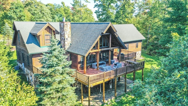 A log cabin with a deck and outdoor seating area. - Family Sanity by Taylor Made Deep Creek (McHenry)