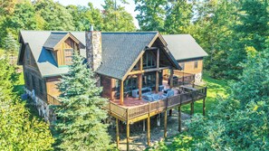 A log cabin with a deck and outdoor seating area. - Family Sanity by Taylor Made Deep Creek (McHenry)