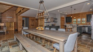 A spacious kitchen with a large island, wooden cabinetry, and a stone backsplash. - Family Sanity by Taylor Made Deep Creek (McHenry)