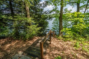 Walk along the boardwalk to a serene dock surrounded by dense forest and water.
