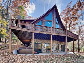 A modern cabin with a stone exterior, a wooden deck, and a large glass window. - Fir Reel by Taylor Made Deep Creek (Oakland)