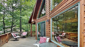 A wooden deck with outdoor seating and large windows. - Fir Reel by Taylor Made Deep Creek (Oakland)