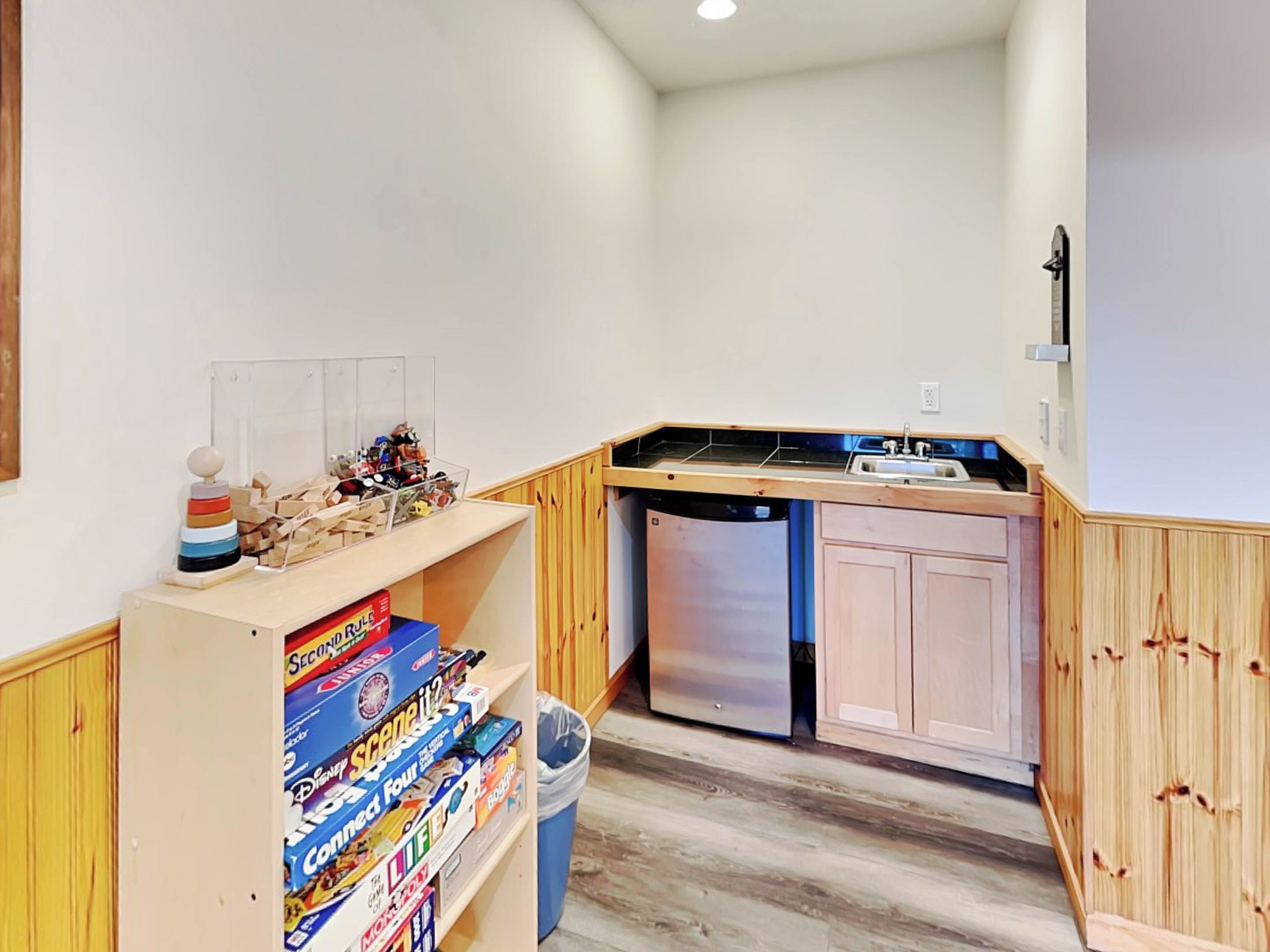 Una cocina compacta con armarios de madera, lavavajillas integrado y un lavamanos pequeño.