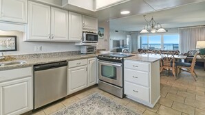 Una cocina moderna con armarios blancos, electrodomésticos de acero inoxidable y una isla grande.