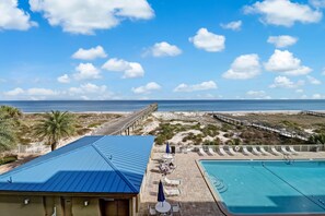 A pool area with a view of the beach and ocean.