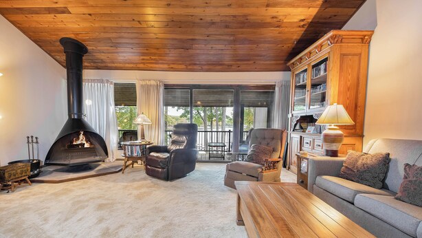 A cozy living room with a fireplace, leather chairs, a sofa, and a wooden coffee table. - Four Hooppole South G6 by Taylor Made Deep Creek (Oakland)