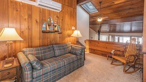 A cozy room with a plaid sofa, wooden rocking chair, and a skylight. - Four Hooppole South G6 by Taylor Made Deep Creek (Oakland)