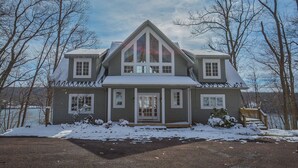 A two-story house with a symmetrical facade, a central entrance, and a steeply pitched roof. - Friday's Escape by Taylor Made Deep Creek (McHenry)