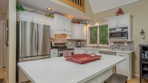 Una cocina moderna con armarios blancos, electrodomésticos de acero inoxidable y una isla grande.