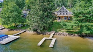 A house with a dock extending into a river, surrounded by trees. - Glencoe by Taylor Made Deep Creek (Oakland)