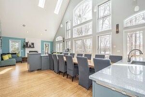 A spacious kitchen with a dining area, large windows, and a modern design.