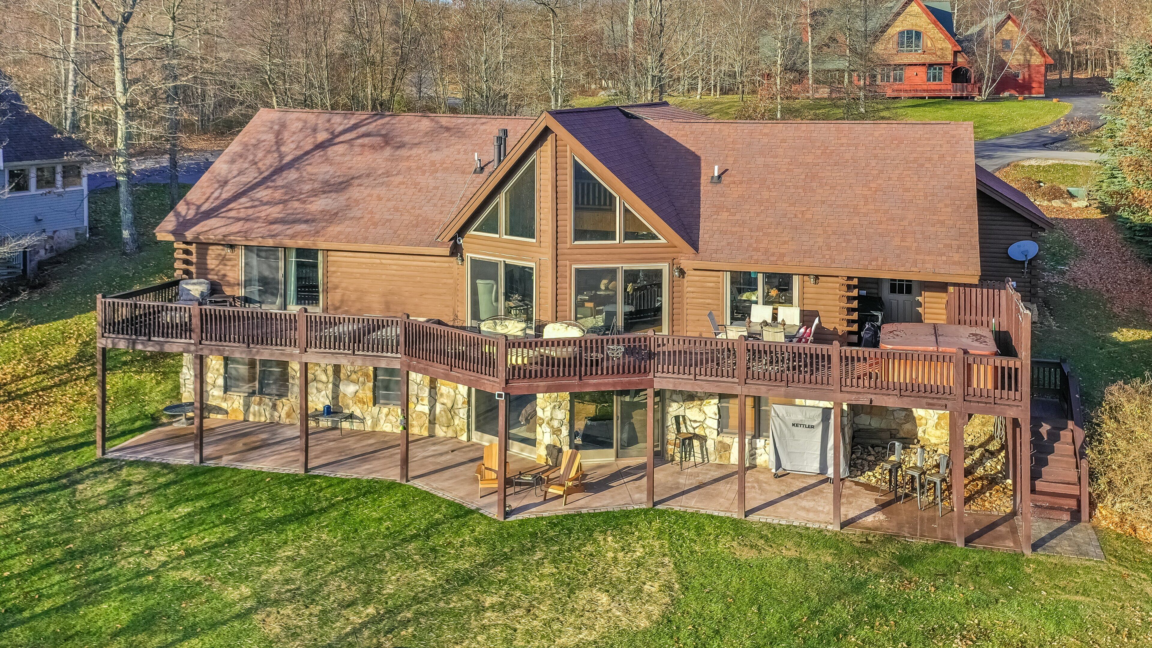 A large wooden house with a spacious deck and multiple windows.