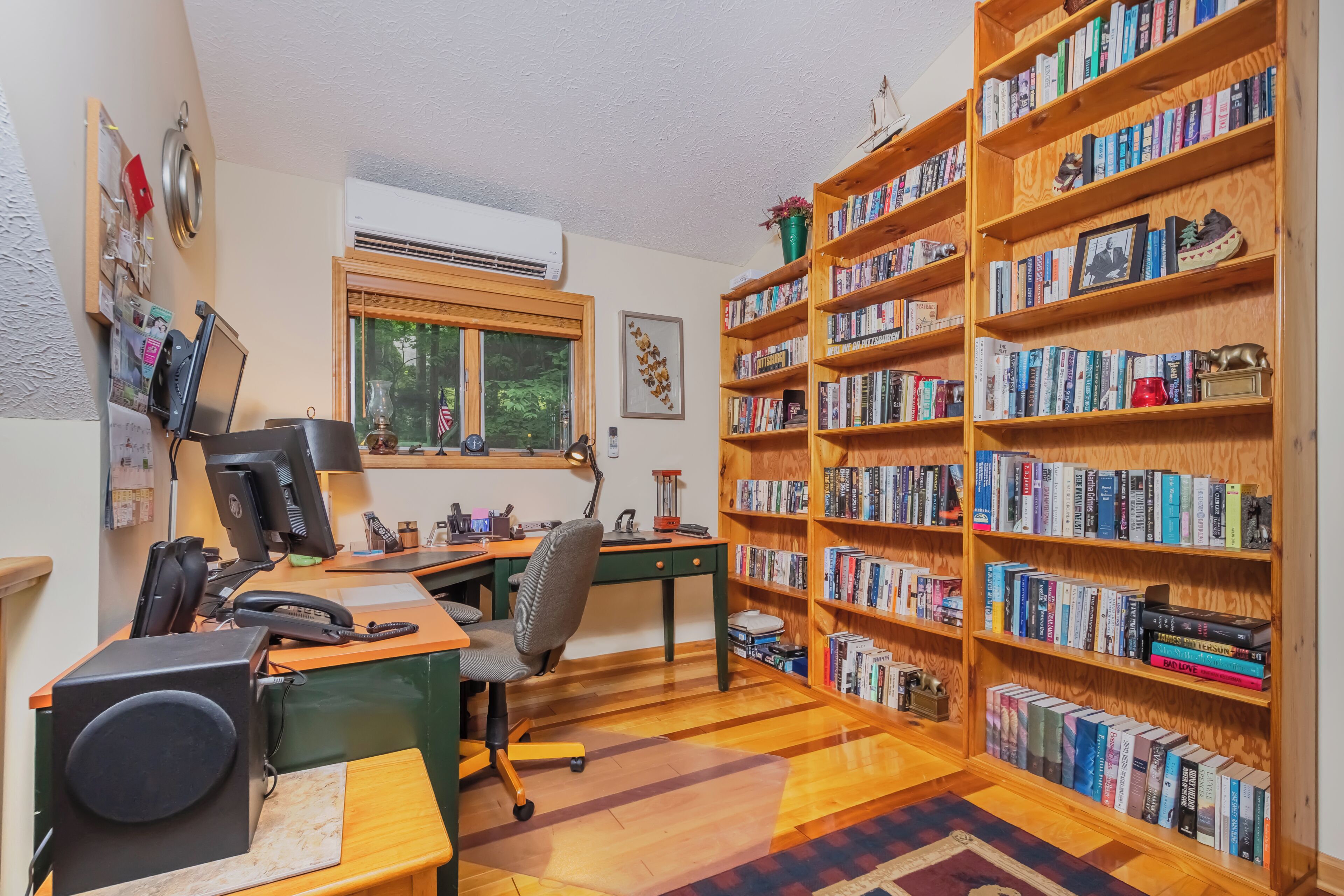 A study room with a desk, chair, bookshelf, and a window.