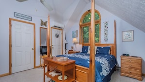 A bedroom with a four-poster bed, a wooden dresser, a vanity with a mirror, and a ceiling fan. - Heart and Soul by Taylor Made Deep Creek (Oakland)