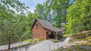 A wooden cabin with a gravel driveway and a covered porch. - Hidden Treasure by Taylor Made Deep Creek (Oakland)