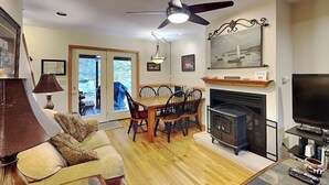 A cozy living room with a fireplace, dining table, and comfortable seating. - Hidden Treasure by Taylor Made Deep Creek (Oakland)