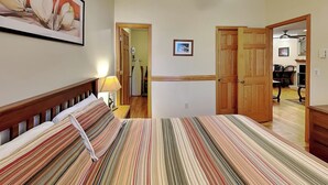 A bedroom with a striped bedspread, wooden headboard, and a ceiling fan. - Hidden Treasure by Taylor Made Deep Creek (Oakland)