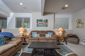 A living room with two couches, a coffee table, and a wicker basket. - Heavenly Grove by Taylor Made Deep Creek (Oakland)
