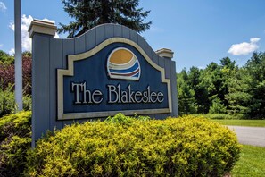 A sign for The Blakeslee with a stylized sun logo. - Heavenly Grove by Taylor Made Deep Creek (Oakland)