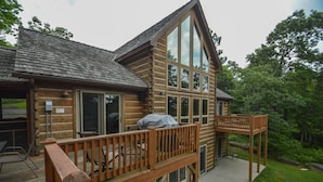 A log cabin with a deck, large windows, and a covered grill area. - High-skis' Villa by Taylor Made Deep Creek (McHenry)