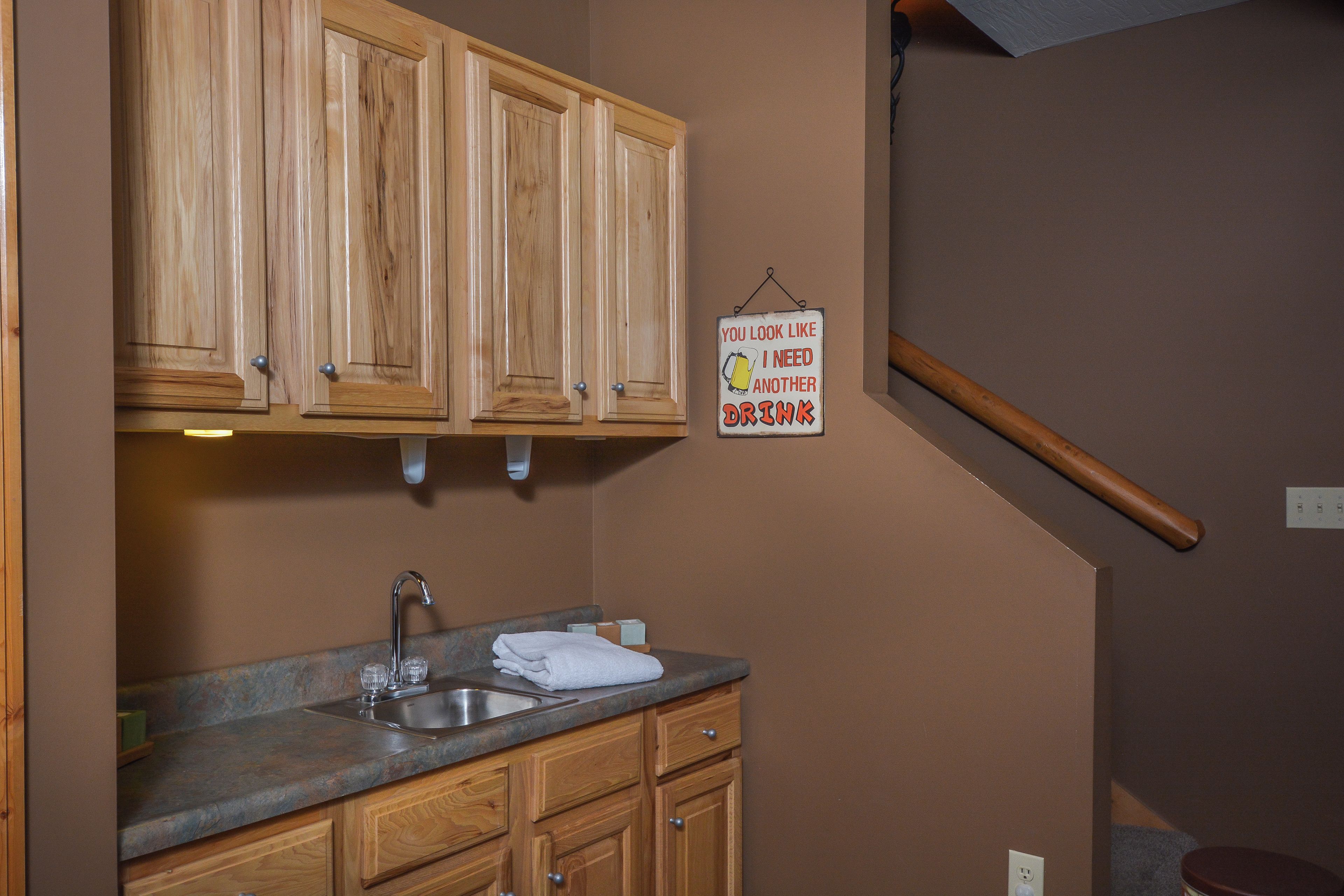 A kitchen with wooden cabinets, a sink, and a towel.