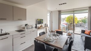A modern kitchen with a dining area, large windows, and a view of the outside. - La Hoguette - La Maison du Benetin (Saint-Malo)
