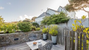 A patio with a table and chairs, surrounded by a stone wall and wooden fence. - La Hoguette - La Maison du Benetin (Saint-Malo)