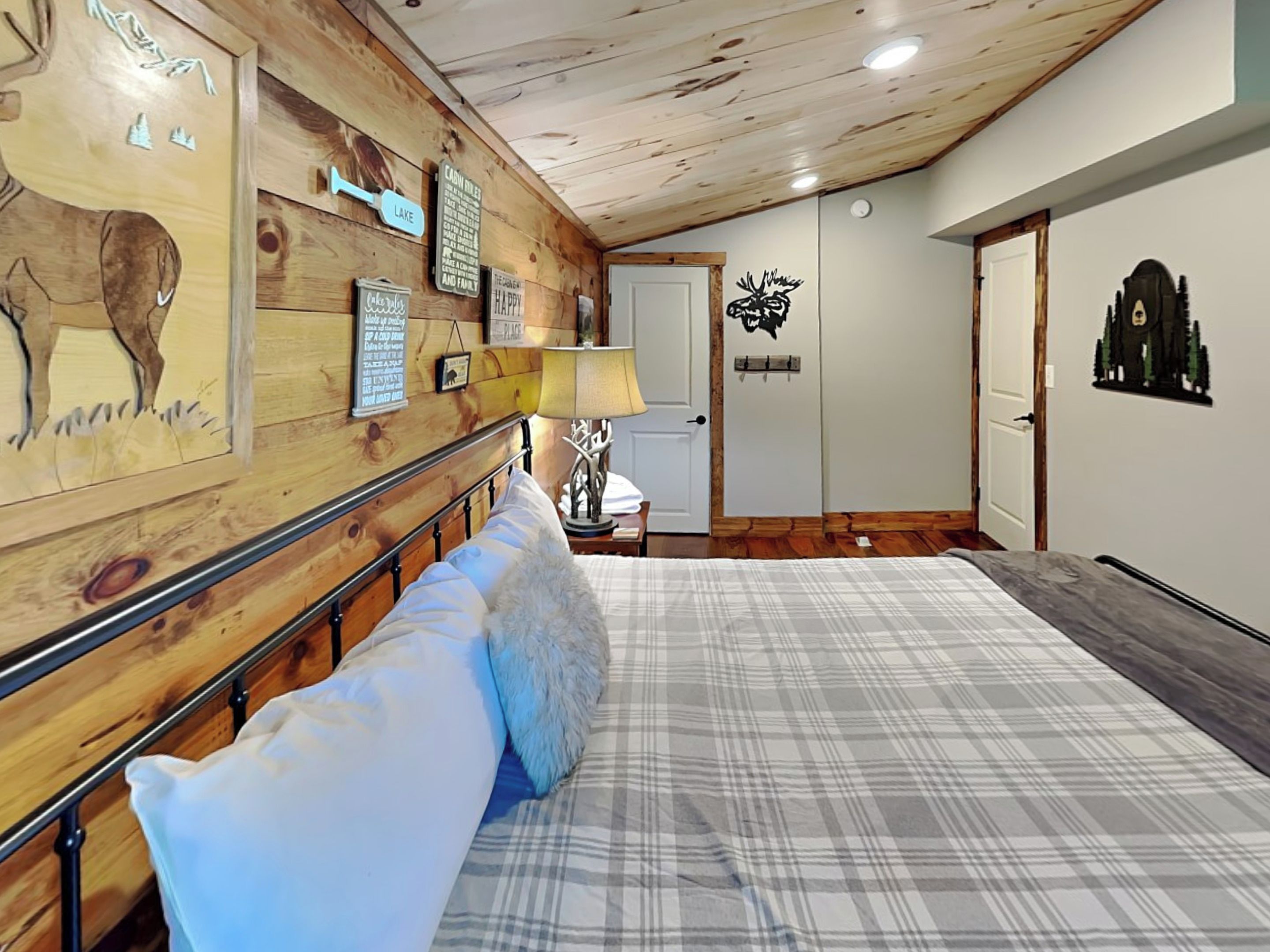 Une chambre à coucher avec un lit, des éléments de décoration murale en bois et une porte.