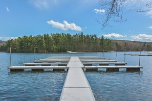 A wooden pier extending into calm water, surrounded by dense forest and a clear sky. - Keep Calm and Lake On by Taylor Made Deep Creek (Swanton)