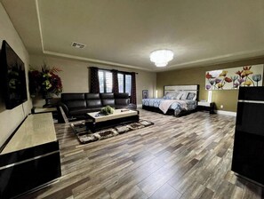 A living room with a sofa, coffee table, and a bed with a headboard.