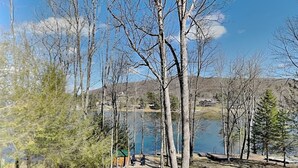Vista de un lago con árboles, un muelle y un camino de piedra.