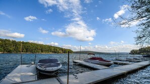 Un muelle con barcos y una orilla cubierta de bosque.