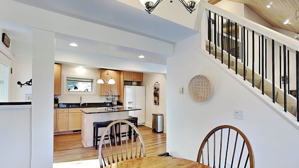 A modern kitchen with wooden cabinets, a central island, and pendant lighting. - Lazy Days by Taylor Made Deep Creek (McHenry)