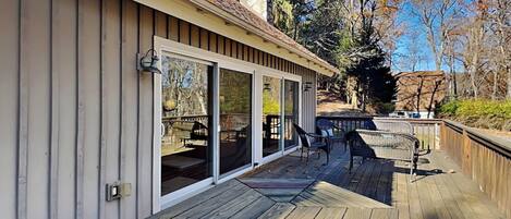 Una terraza con un diseño hexagonal, una puerta corrediza de vidrio y mobiliario exterior.