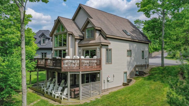 A two-story house with a balcony, outdoor seating, and a garage. - Leap Away by Taylor Made Deep Creek (Oakland)