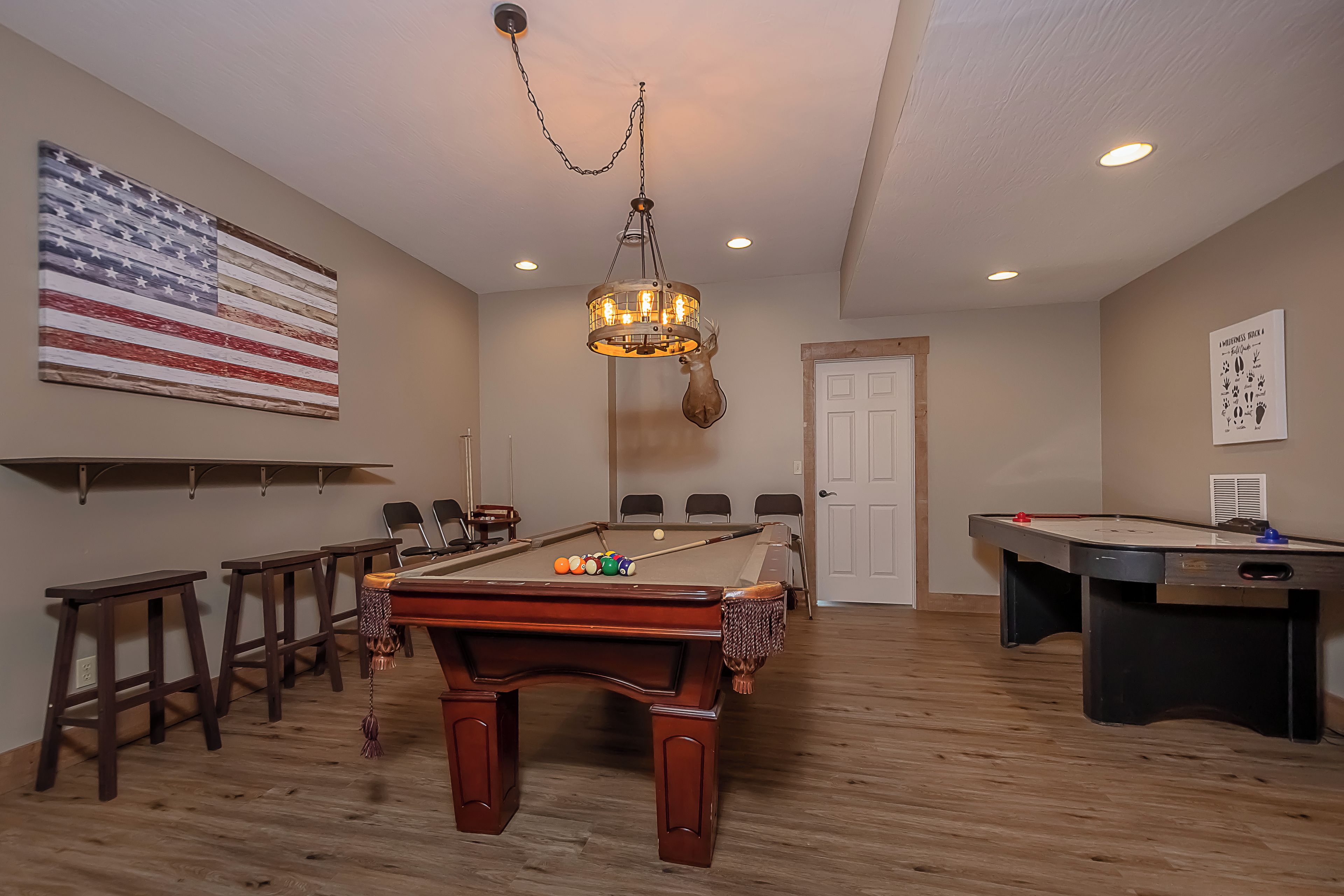 Une table de billard avec des billes, une table de snooker et un drapeau accroché au mur.