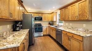 A kitchen with wooden cabinets, stainless steel appliances, and a granite countertop.