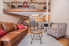 Relax in this inviting living area with a leather sofa, patterned armchair, and glass coffee table.