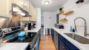 A modern kitchen with stainless steel appliances, wooden cabinets, and a built-in oven.
