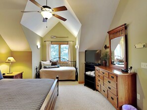 A bedroom with a bed, a dresser, a television, and a ceiling fan. - Midnight Dip by Taylor Made Deep Creek (Swanton)
