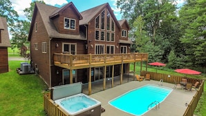 A two-story wooden house with a deck, a hot tub, and a swimming pool. - Midnight Dip by Taylor Made Deep Creek (Swanton)
