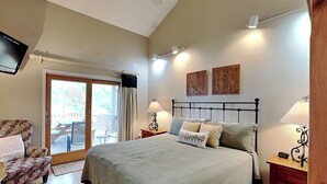 A bedroom with a bed, a chair, a desk, a lamp, and a television. - Million Dollar View by Taylor Made Deep Creek (McHenry)